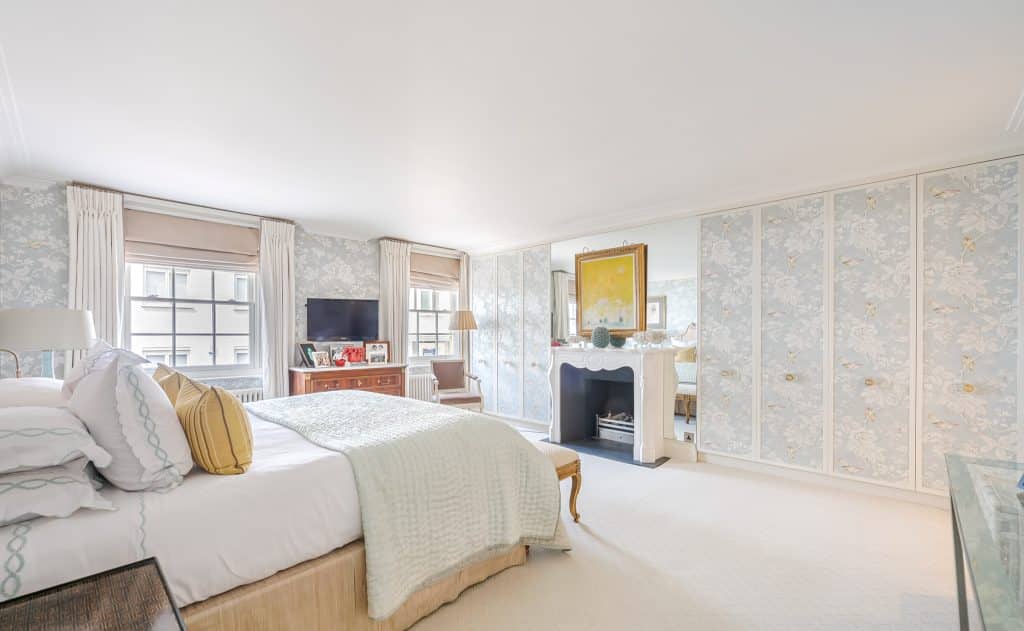 a bedroom with a bed and a chair in a room