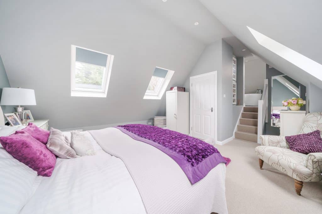 a bedroom with a purple blanket on a bed