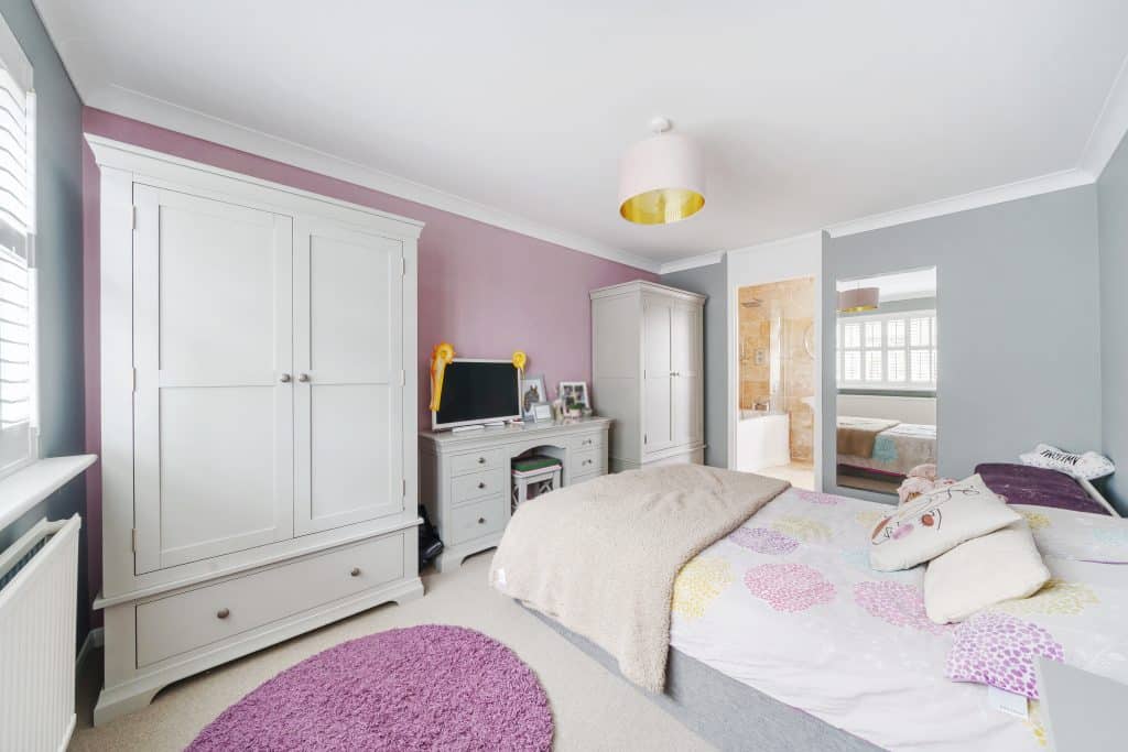 a bedroom with a bed and desk in a room