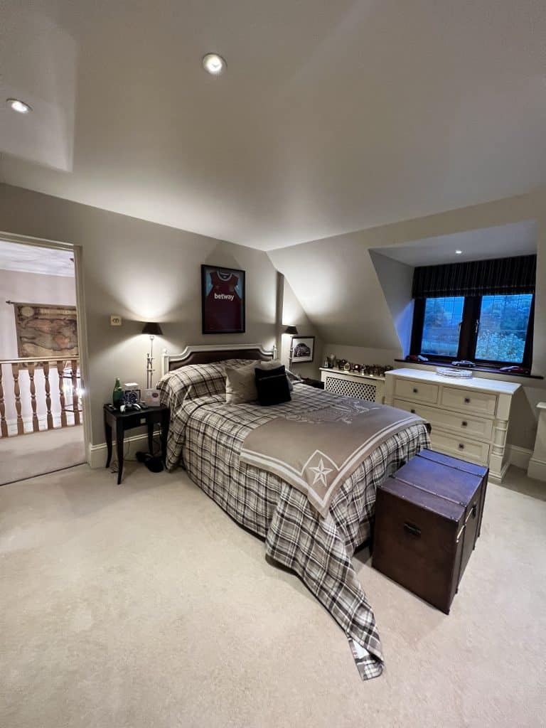 a bedroom with a bed and desk in a room