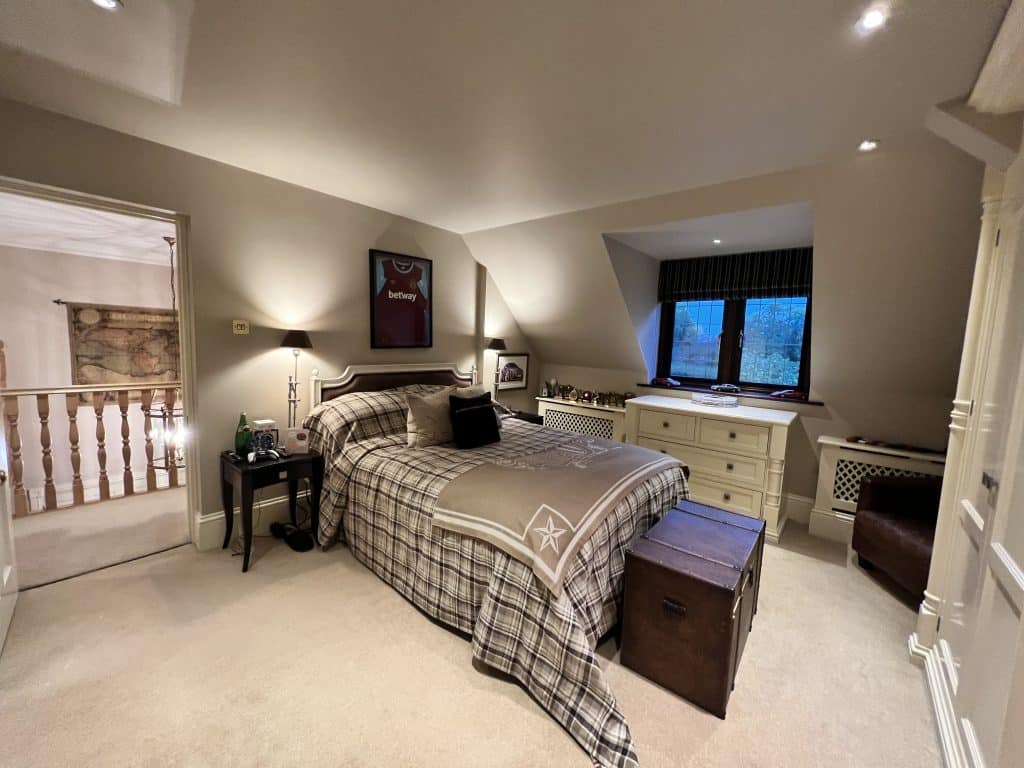 a bedroom with a bed and desk in a room