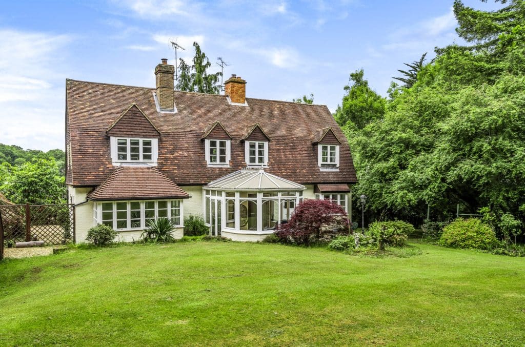 a large brick building with green grass in front of a house