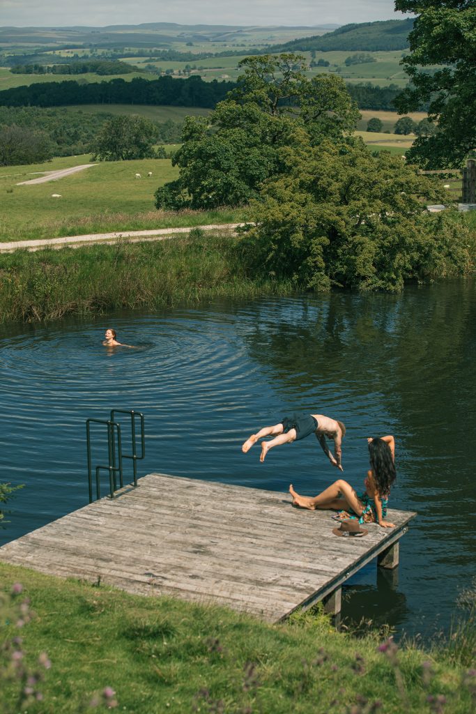 a person sitting on a bench next to a body of water