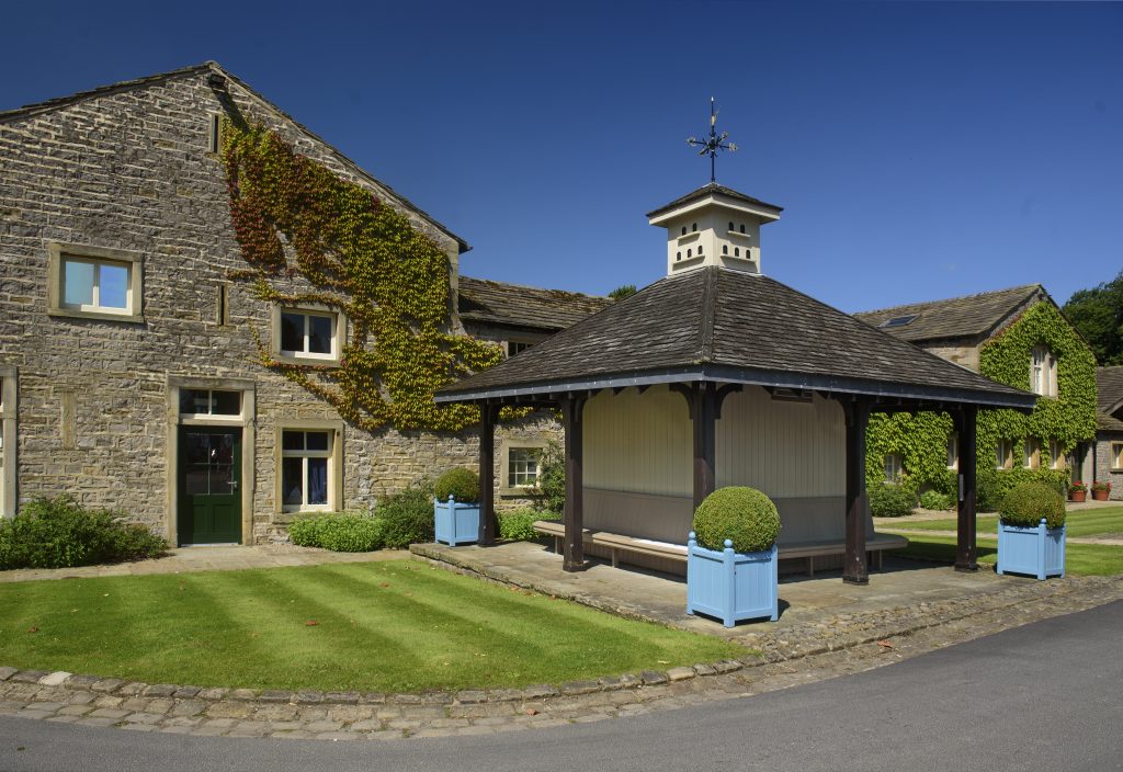 a large brick building with grass in front of a house