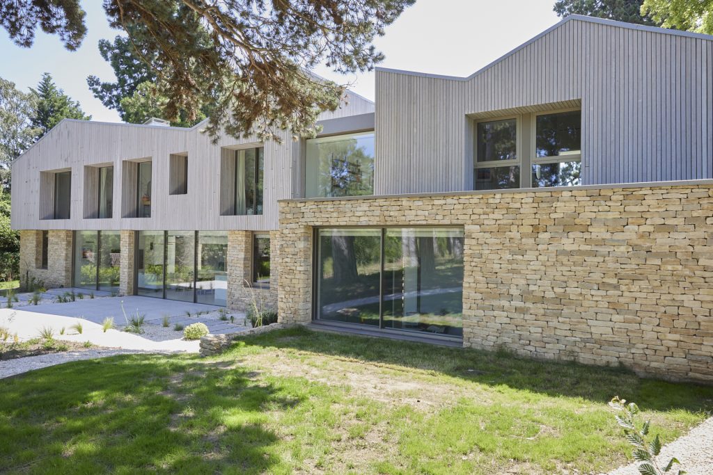 a large brick building with grass in front of a house