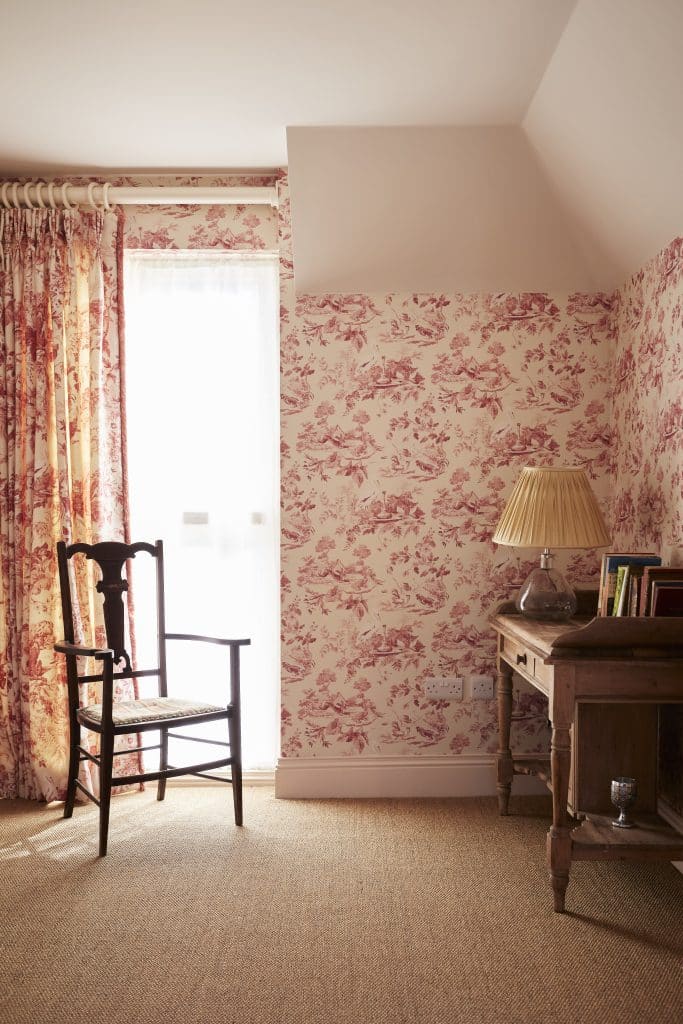 a bedroom with a bed and a chair in a room