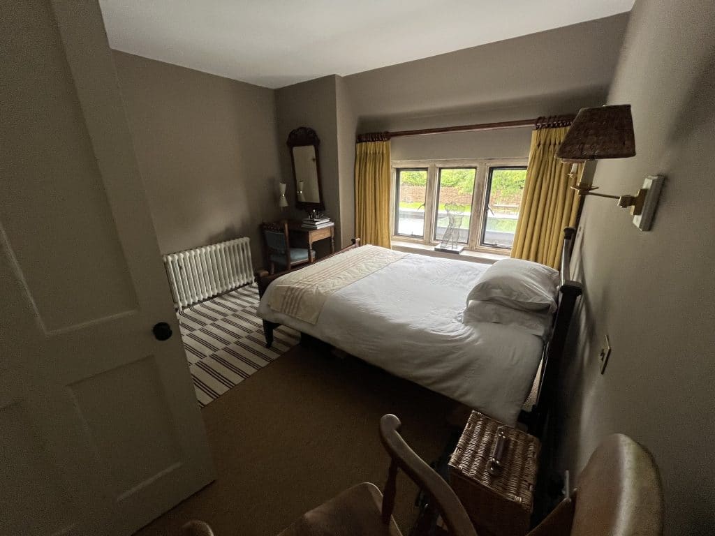 a bedroom with a bed and a mirror in a room