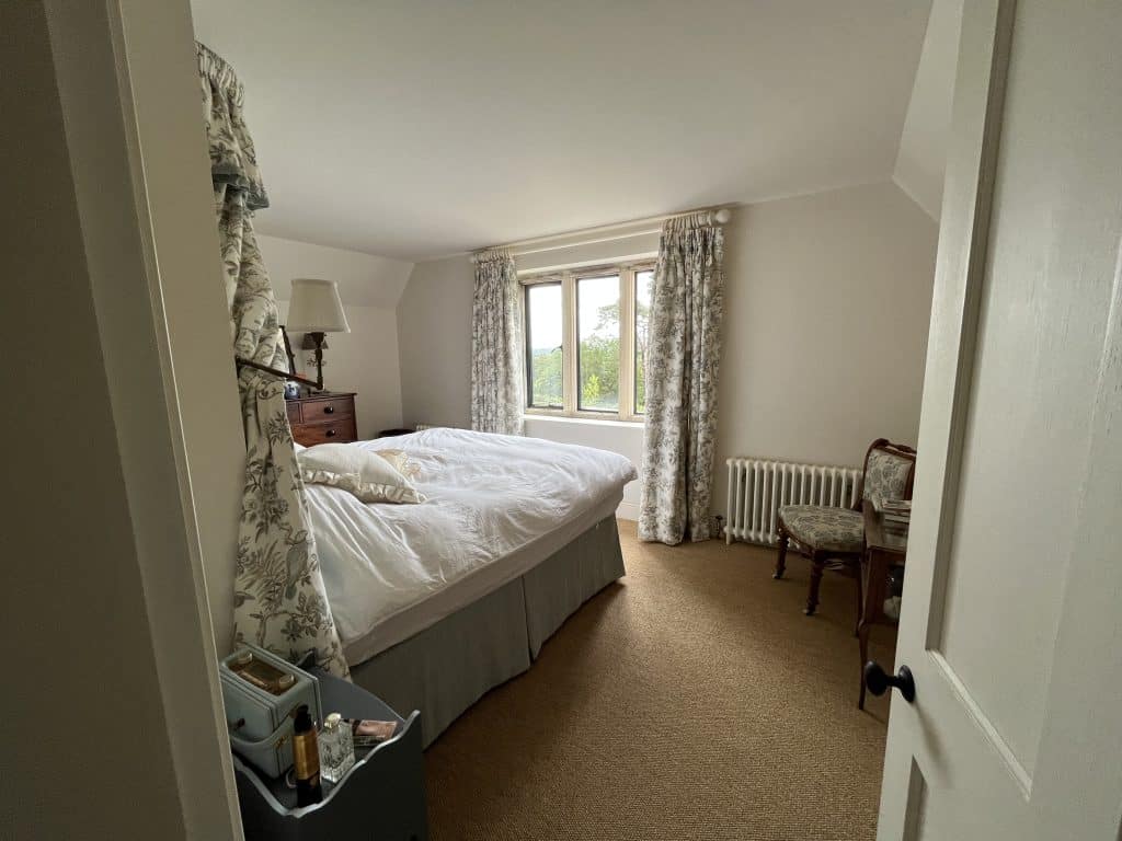 a bedroom with a bed and a mirror in a room