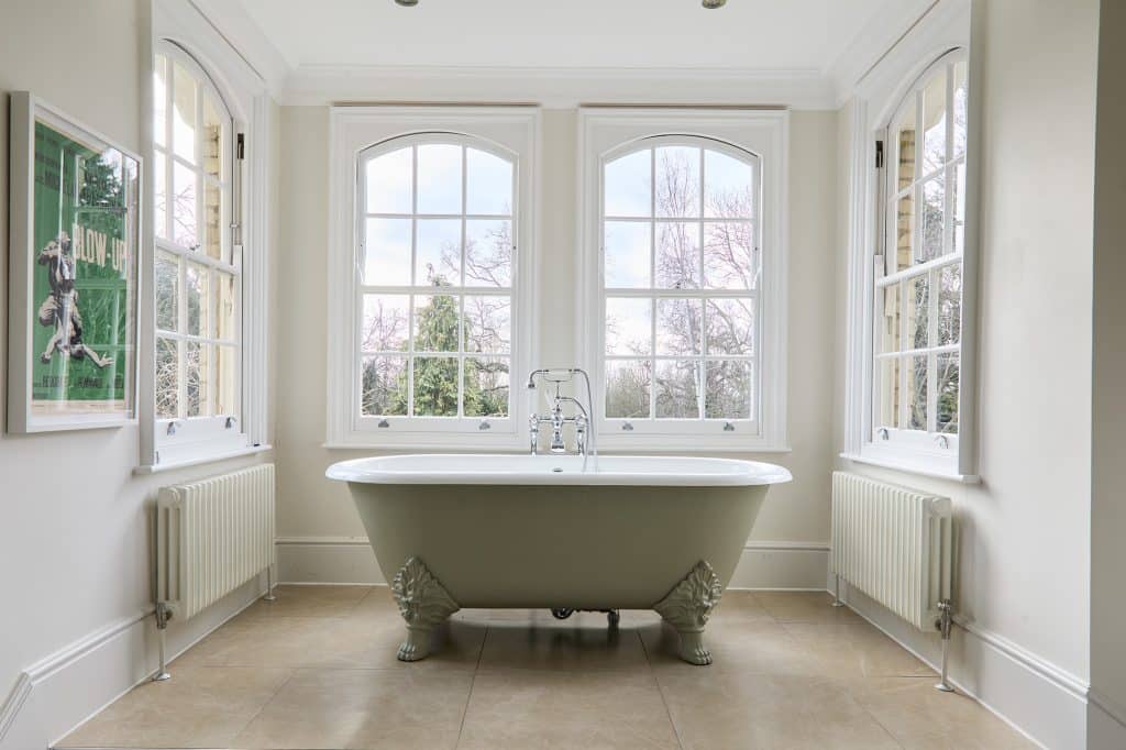 a room with a large tub next to a window
