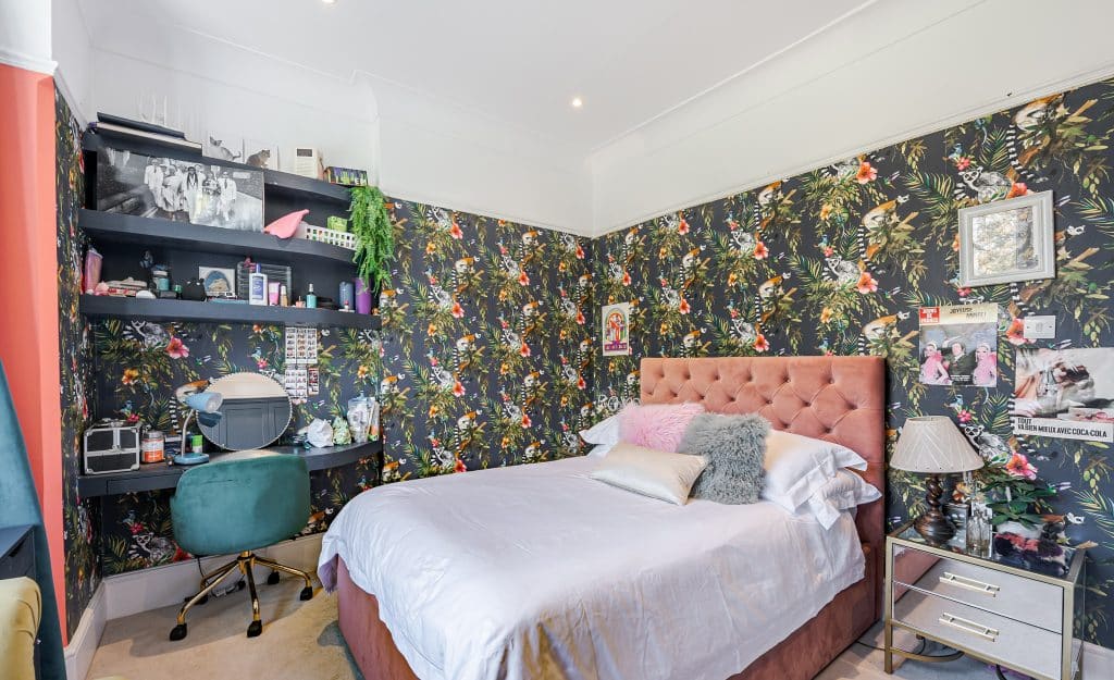 a bedroom with a bed and desk in a room