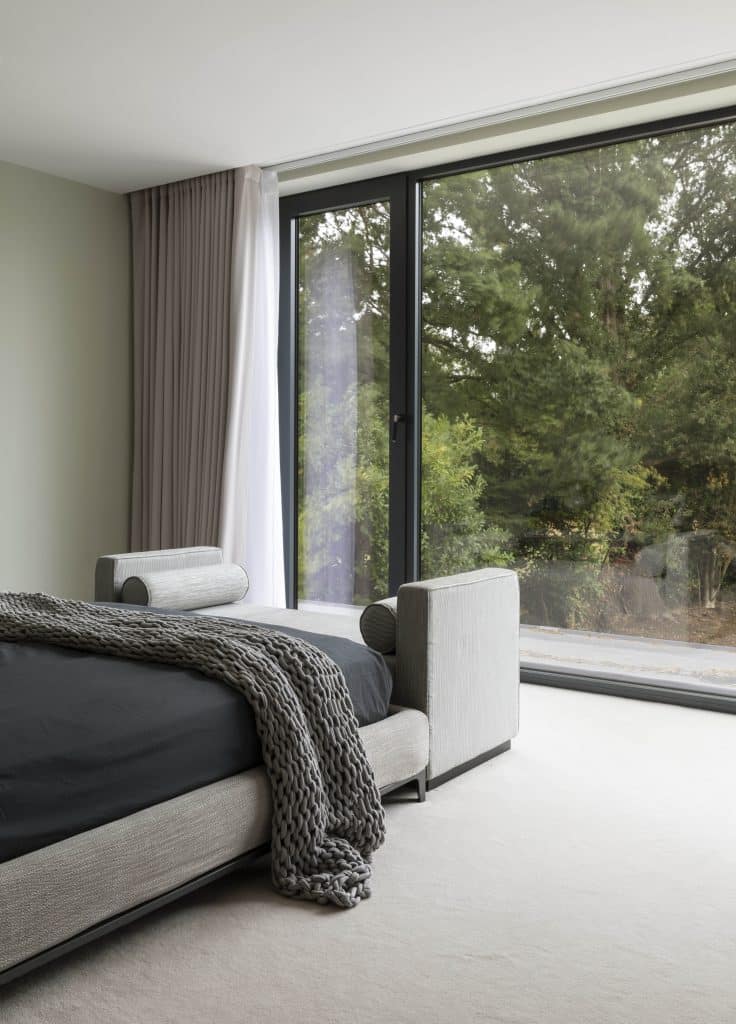 a large bed sitting next to a window