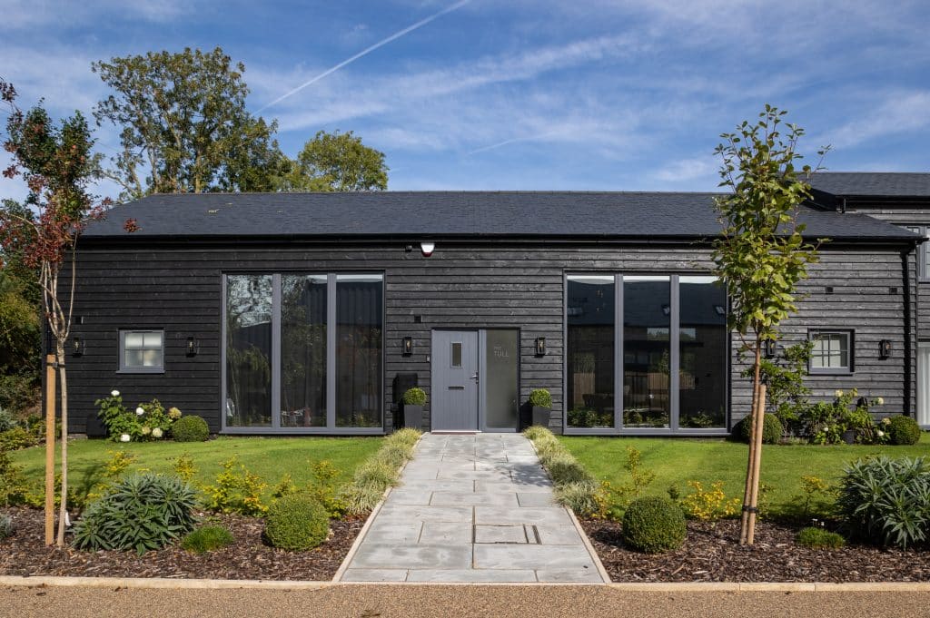 a house with bushes in front of a brick building