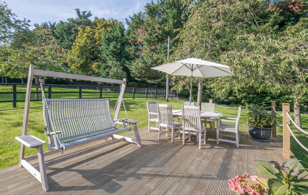 a group of lawn chairs sitting on top of a wooden fence
