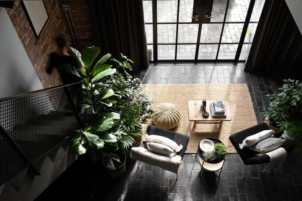 a living room filled with furniture and vase of flowers on a plant