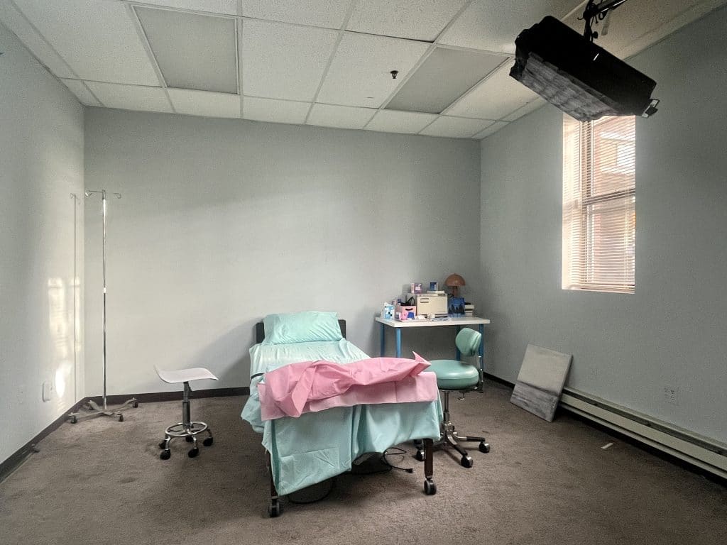 a bedroom with a bed and desk in a room