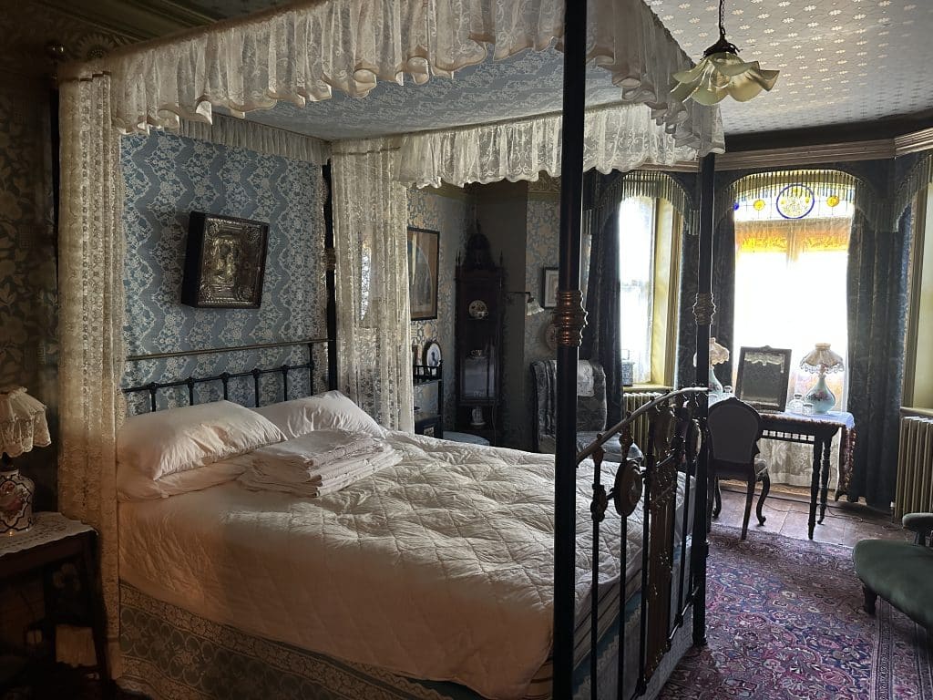 a bedroom with a bed and a chair in a room